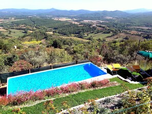 A swimming pool with a view of a hilly landscape.