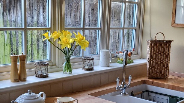 A kitchen with a wooden countertop, a sink, and a window with a view of trees. - Peaceful, Picturesque, Stylish Property in Benenden Converted Barn (Cranbrook Rd)