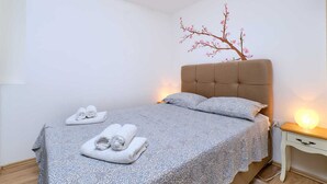 Une chambre à coucher avec un lit, des oreillers et une table de chevet.