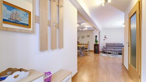 Un vaste espace de vie doté d’un plancher en bois, d’une table à manger avec des chaises, d’un canapé et d’une cheminée.