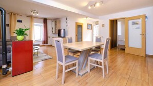 Un espace repas moderne avec une table et des chaises en bois, un appareil électroménager rouge et une plante en pot.