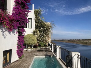 A poolside area with a wooden deck, a swimming pool, and a view of a river. - House with character (Azemmour)