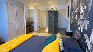 Une chambre à coucher comprenant un lit, une armoire, un miroir et un escalier menant à une autre pièce.