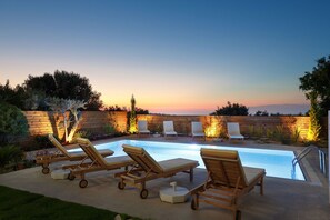 A pool area with wooden lounge chairs and a wooden fence. - Spacious Villa With Full Privacy Next to the City & the Sandy Beach of Rethymno! (Rethymno)