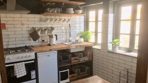 Une cuisine avec un dosseret de carrelage blanc, un plan de travail en bois et une fenêtre offrant une belle vue.
