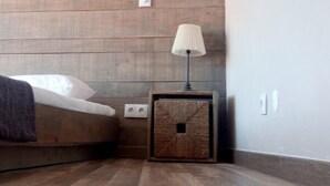 Une chambre à coucher avec une tête de lit en bois, une table de chevet avec une lampe et un lit avec un oreiller blanc.