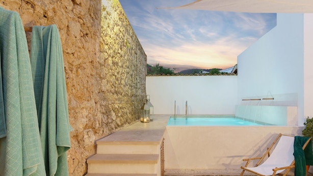Un mur de pierre, une piscine et une chaise.