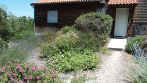 A wooden house with a tiled roof and a gravel path leading to the door. - Timber frame house with garden (Vers)
