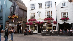 En pub som heter ”The Greene Room”, med blomlådor och en skylt med texten ”The Cricketers”.