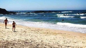 Una playa con cielos despejados y aguas tranquilas.