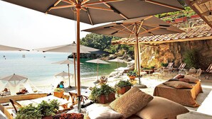 A beachside lounge with outdoor seating, umbrellas, and potted plants. - Podere dei Poeti 20 Pax Large pool, A / C, free WiFi, BBQ near Cinque Terre (Canova)