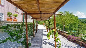 A covered walkway with a pergola structure, potted plants, and a gravel path leading to a building. - Podere dei Poeti 20 Pax Large pool, A / C, free WiFi, BBQ near Cinque Terre (Canova)
