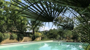 A swimming pool with a clear blue water surface, surrounded by lush greenery and a pergola structure. - Podere dei Poeti 20 Pax Large pool, A / C, free WiFi, BBQ near Cinque Terre (Canova)