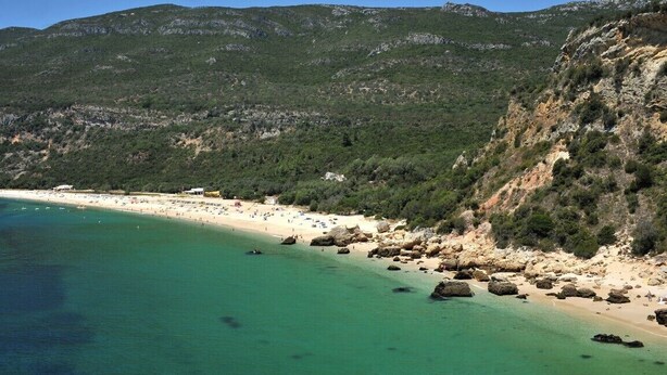 A coastal beach with clear turquoise waters, rocky shoreline, and a mountainous backdrop. - Farmhouse - Sea and Mountains (Setubal)
