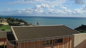 Un balcón con vista al mar y una antena parabólica.