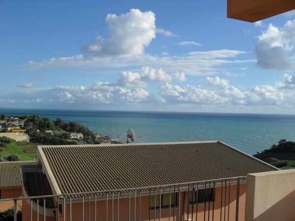 A balcony with a view of the sea and a satellite dish.