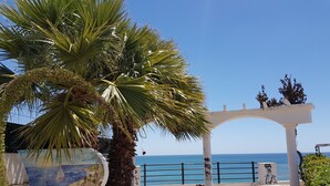 A paved walkway with a white archway and benches, leading to a view of the sea. - Sea View , Free Wifi, walking distante from the strip (Albufeira)