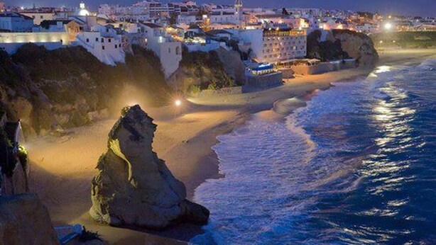 A coastal town with buildings along the shore, rocky outcrops, and a beach. - Sea View , Free Wifi, walking distante from the strip (Albufeira)