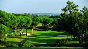 A golf course with sand bunkers, trees, and a clear sky. - Sea View , Free Wifi, walking distante from the strip (Albufeira)