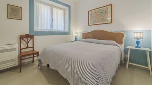 Une chambre à coucher avec un lit, une chaise, un bureau et une fenêtre.