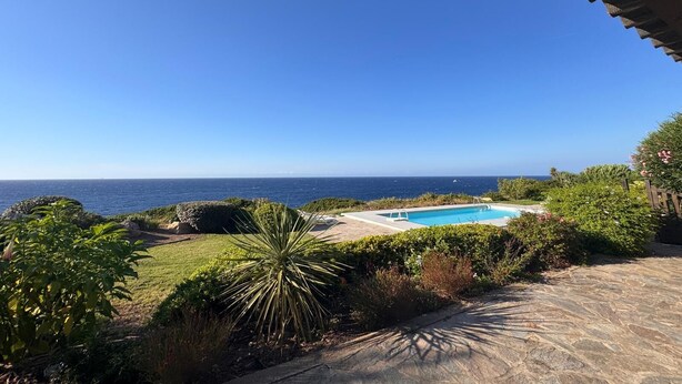 A pool with a view of the ocean, surrounded by greenery and a stone pathway. - WONDERFUL VILLA ON THE SEA 8/10 PEOPLE  (Lumio)