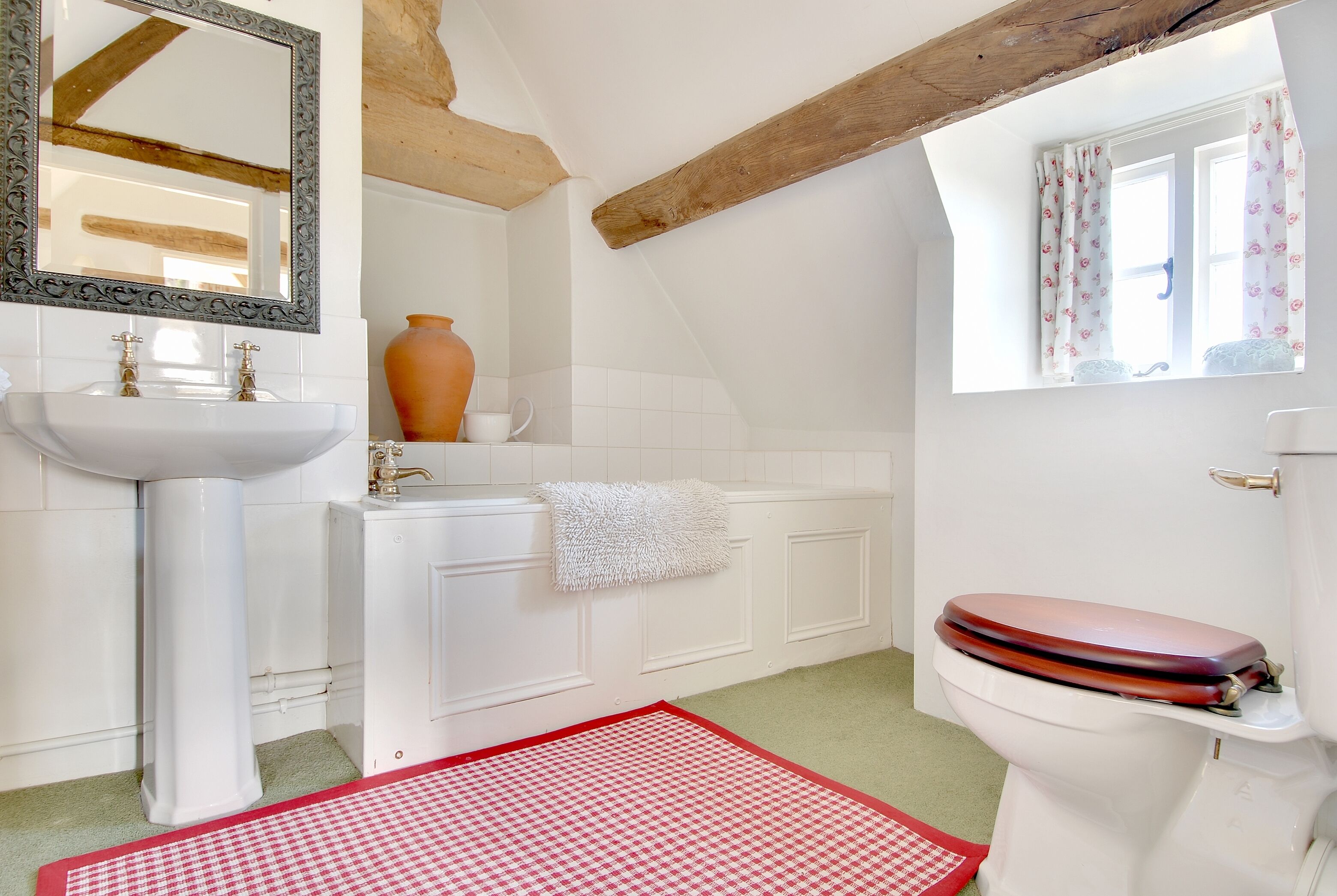 A bathroom with a white sink, a bathtub, and a toilet.