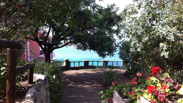 A pathway leading to a scenic overlook with a stone wall on one side and a wooden fence on the other. - studio - 1 room - 3/4 persons (Torre Delle Stelle)
