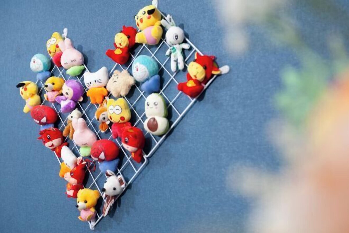 A collection of colorful plush toys arranged on a wire rack.