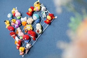 A collection of colorful plush toys arranged on a wire rack. - Dinghushan Hotel (Zhaoqing)