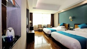 A hotel room with two beds, a desk, a chair, a lamp, and a window with curtains. - Dinghushan Hotel (Zhaoqing)