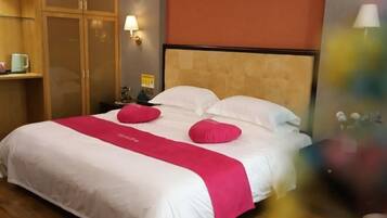 Une chambre d’hôtel avec un lit, une table de chevet, une lampe et une armoire.