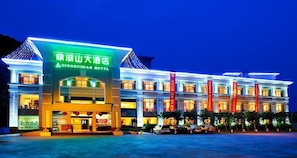 A hotel with a prominent entrance, multiple floors, and a parking area. - Dinghushan Hotel (Zhaoqing)