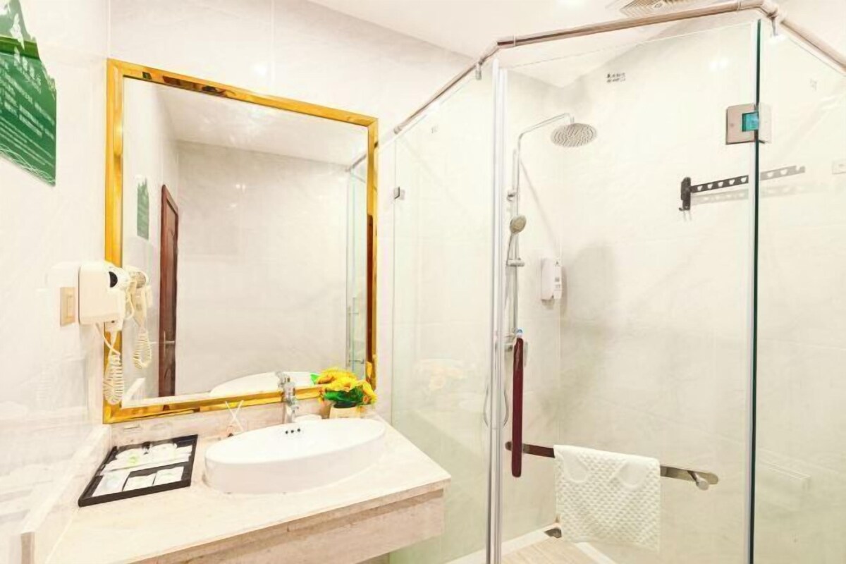 A modern bathroom with a glass-enclosed shower, a large mirror, and a sink with a vanity.
