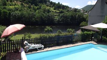 Een buitenzwembad en ligstoelen