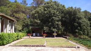 Un jardin agrémenté d’un belvédère, d’un sentier en pierre et d’un bâtiment orné de colonnes.