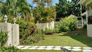 Ein gepflegter Garten mit vielfältigen Pflanzen und einem weißen Zaun.