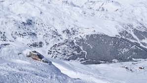 Een berglandschap bedekt met sneeuw, met een skigebied.