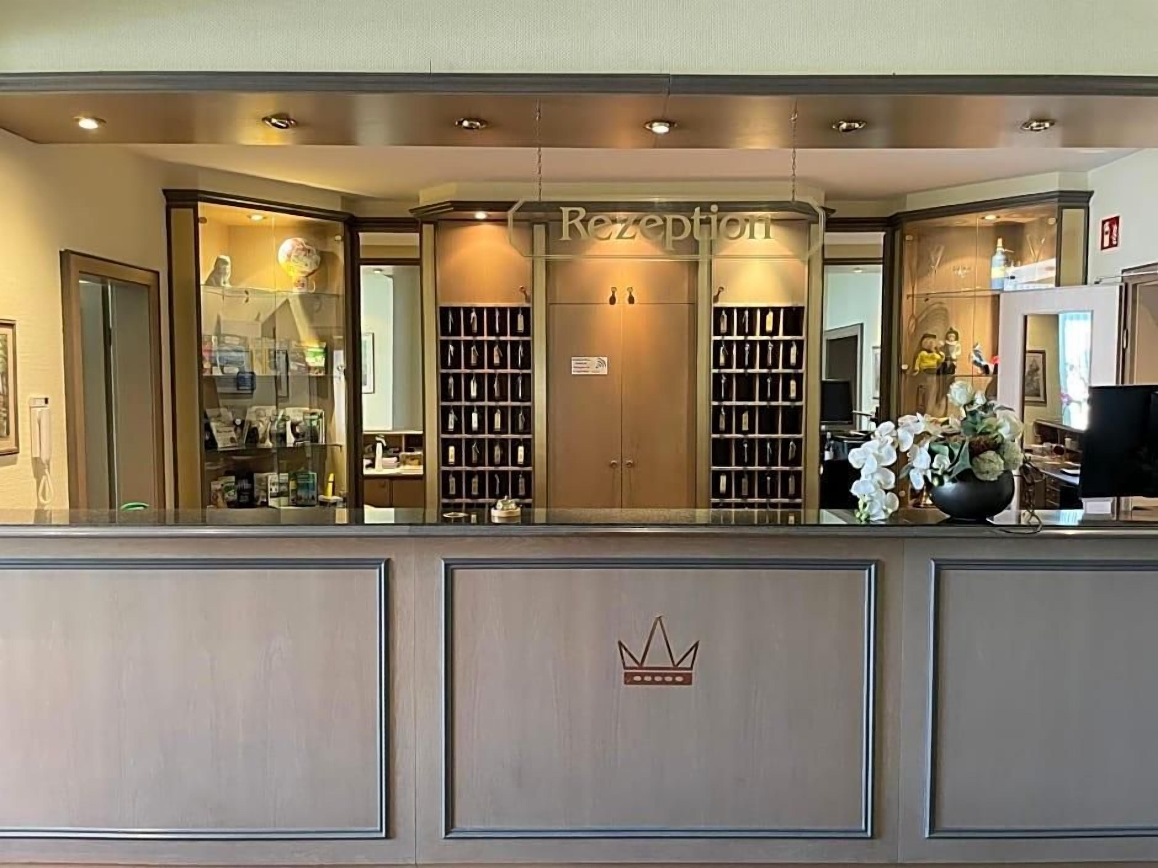 A reception area with a counter, glass display cases, and a crown emblem.