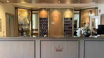 A reception area with a counter, glass display cases, and a crown emblem.