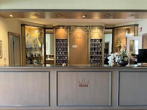 A reception area with a counter, glass display cases, and a crown emblem.