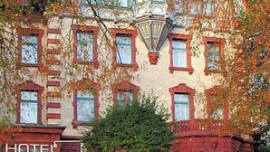 A historic building with a red brick facade, multiple windows, and a sign indicating it is a hotel.