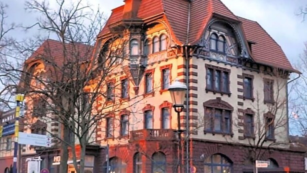 A historic building with multiple stories, large windows, and a prominent corner entrance.