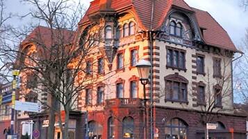 A historic building with multiple stories, large windows, and a prominent corner entrance.