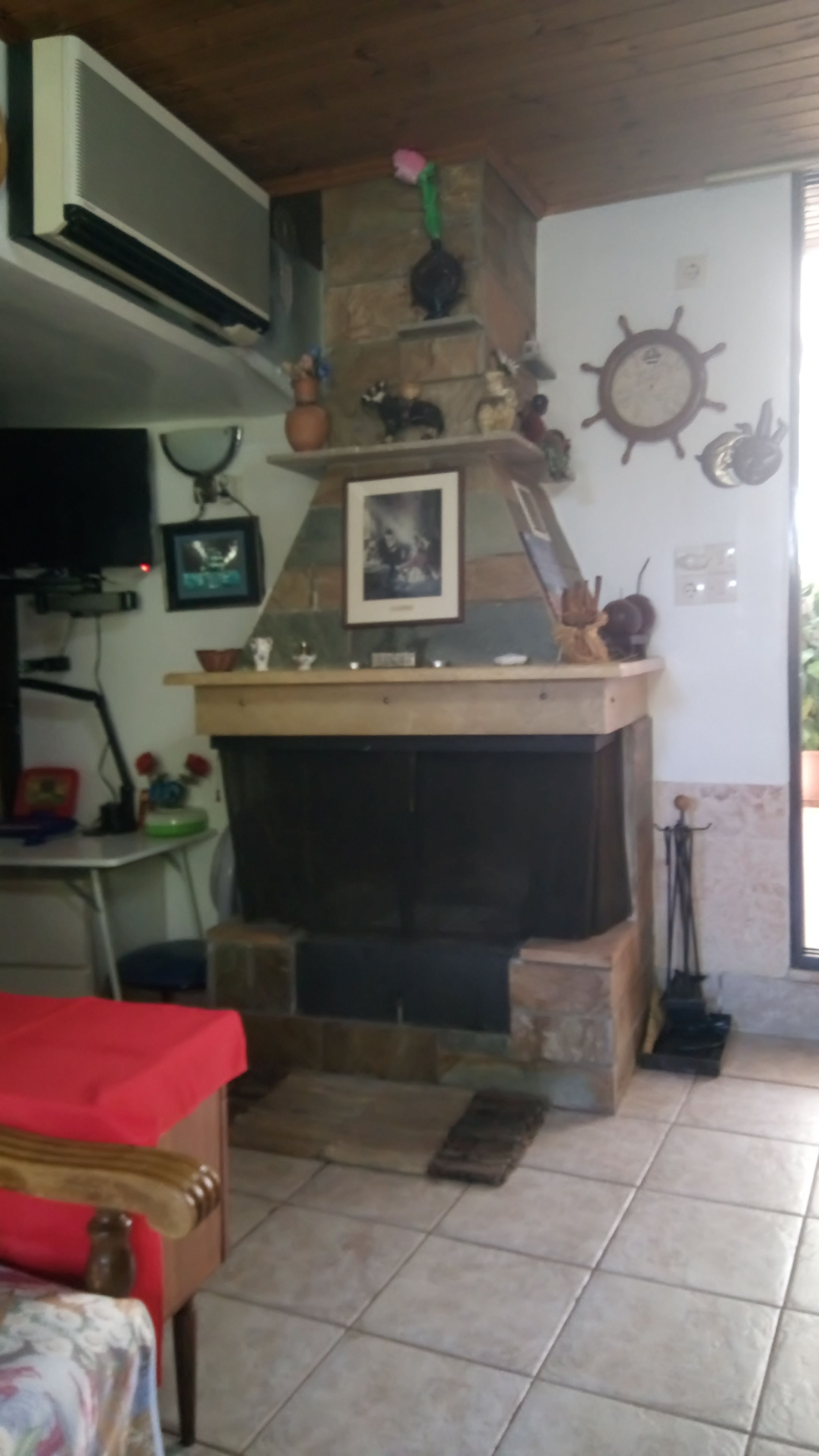 A living room with a fireplace, a television, and a wall clock.