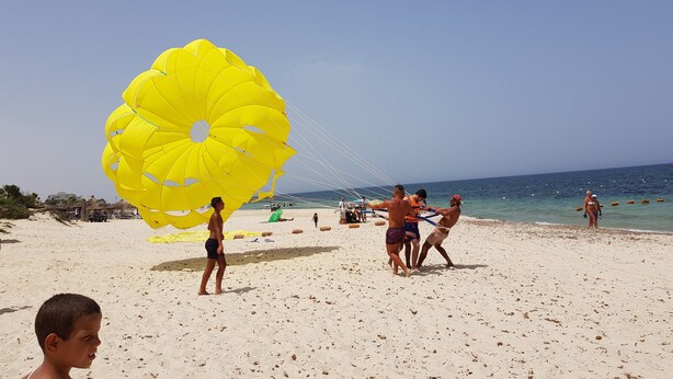 A beach with people, including a man and a woman, and a large yellow parasail. - house / villa - SOUSSE (Sousse)