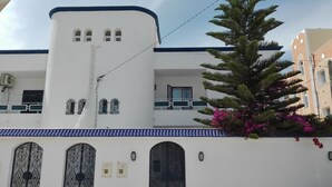 A white building with a blue roof, arched windows, and a central tower. - house / villa - SOUSSE (Sousse)