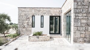 A modern building with stone walls and large glass windows. - Magnificent Villa in Alberobello with Trulli and exclusive salt water swimming pool (Alberobello)
