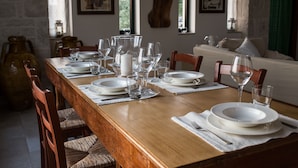 A dining table set with plates, glasses, and cutlery, surrounded by wooden chairs. - Magnificent Villa in Alberobello with Trulli and exclusive salt water swimming pool (Alberobello)