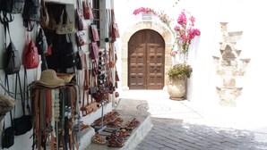 Una boutique con una selezione di borse e scarpe esposte all'esterno.