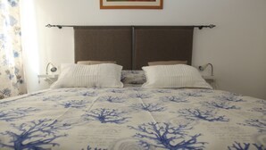 A bed with a floral bedspread, two bedside tables, a nightstand, and a wall-mounted lamp. - BLUE DIAMOND in the 5Terre-Cod. Citra 011019-LT-0241 (Monterosso al Mare)
